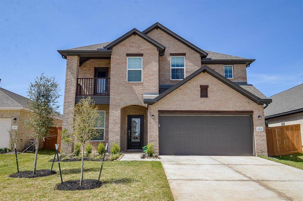 A front exterior view of the house showing a two-story design with a driveway and landscaped yard.