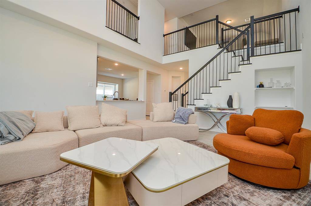 Another angle of the living room, showcasing an open floor plan and staircase.