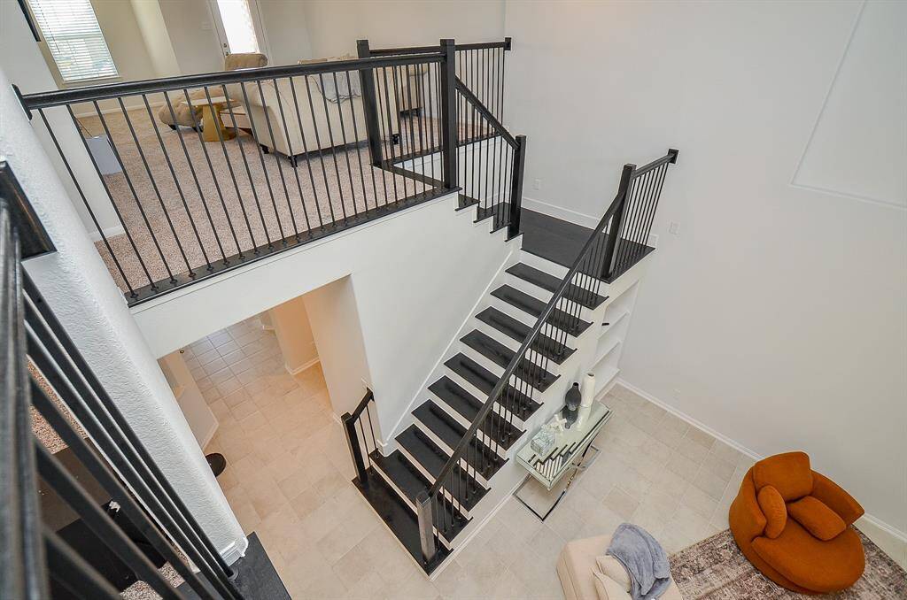 A bird’s-eye view of the staircase and open-concept living space.