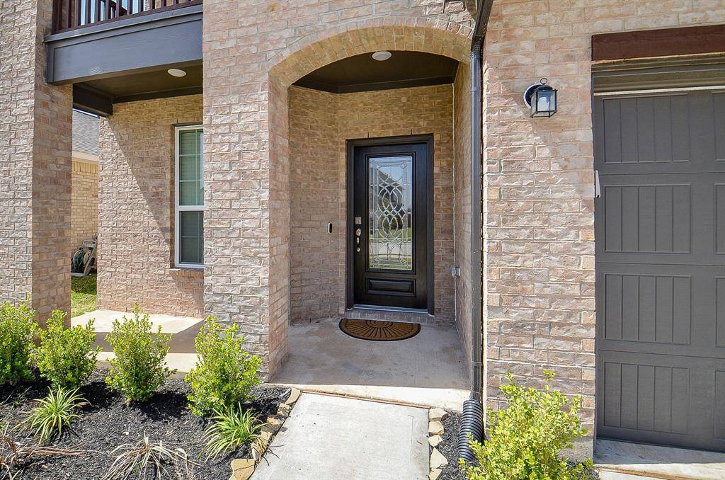A close-up of the front entrance featuring a brick facade and modern door.