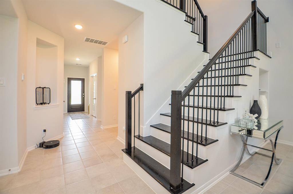 A staircase with sleek black railings leading to the second floor.