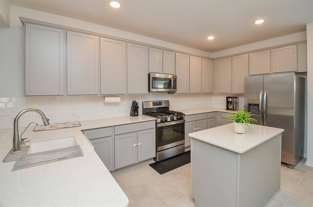 A spacious open kitchen with a large island and modern cabinetry.