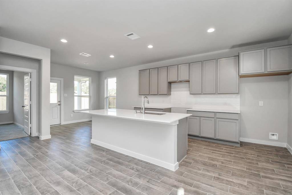 Experience the epitome of a dream kitchen in this generously spacious layout! Revel in features like a massive granite island, high ceilings, soft-close cabinets, granite countertops, stainless steel appliances, a sleek tile backsplash, and recessed lighting. With an open concept design, this kitchen seamlessly connects to the expansive family room, creating a perfect and inviting hub for gatherings. Sample photo of completed home with similar floor plan. Actual colors and selections may vary.