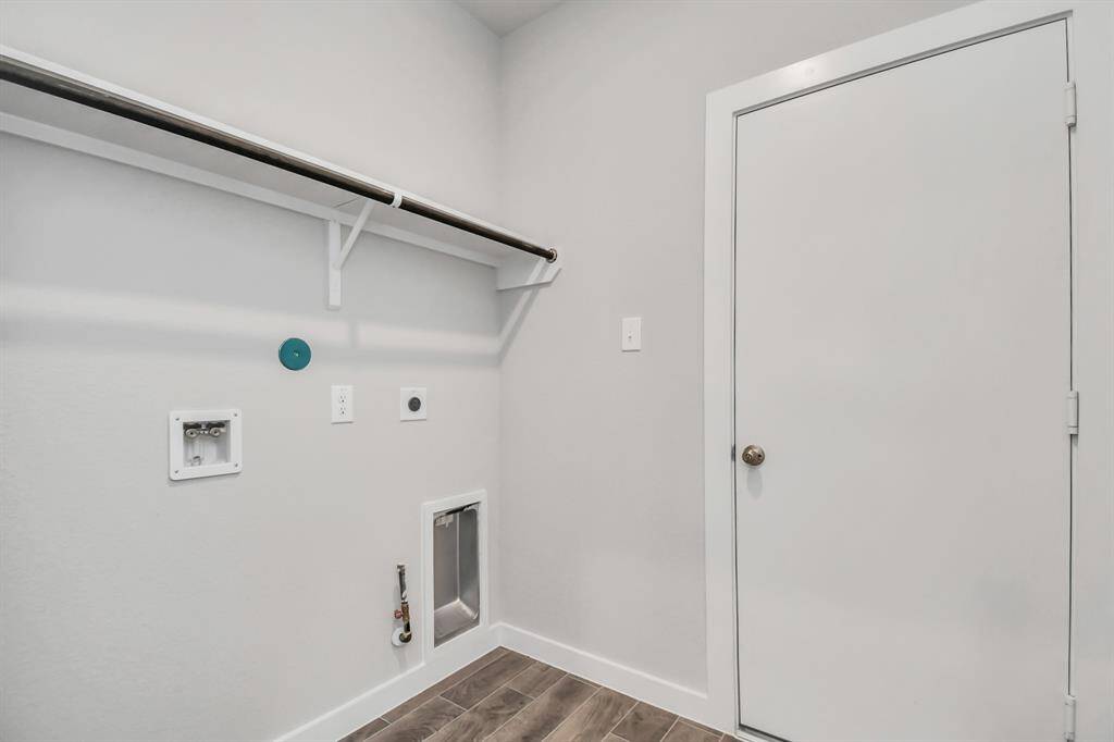 Located on first floor, a stylish laundry room where practicality meets a contemporary aesthetic. The dark finishes lend a sophisticated touch, creating a space that is both functional and visually appealing. Sample photo of completed home with similar floor plan. Actual colors and selections may vary.