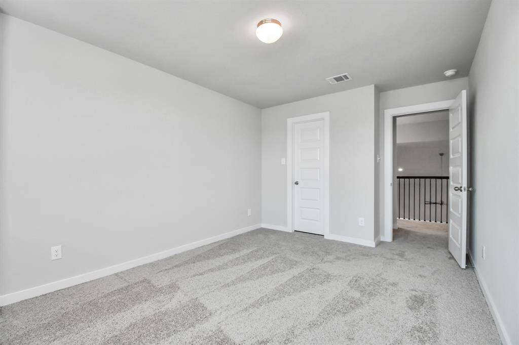 Secondary bedrooms showcase 5-panel doors adorned with modern hardware, large windows enhanced by privacy blinds, and spacious closets featuring sleek and contemporary finishes. Sample photo of completed home with similar floor plan. Actual colors and selections may vary.