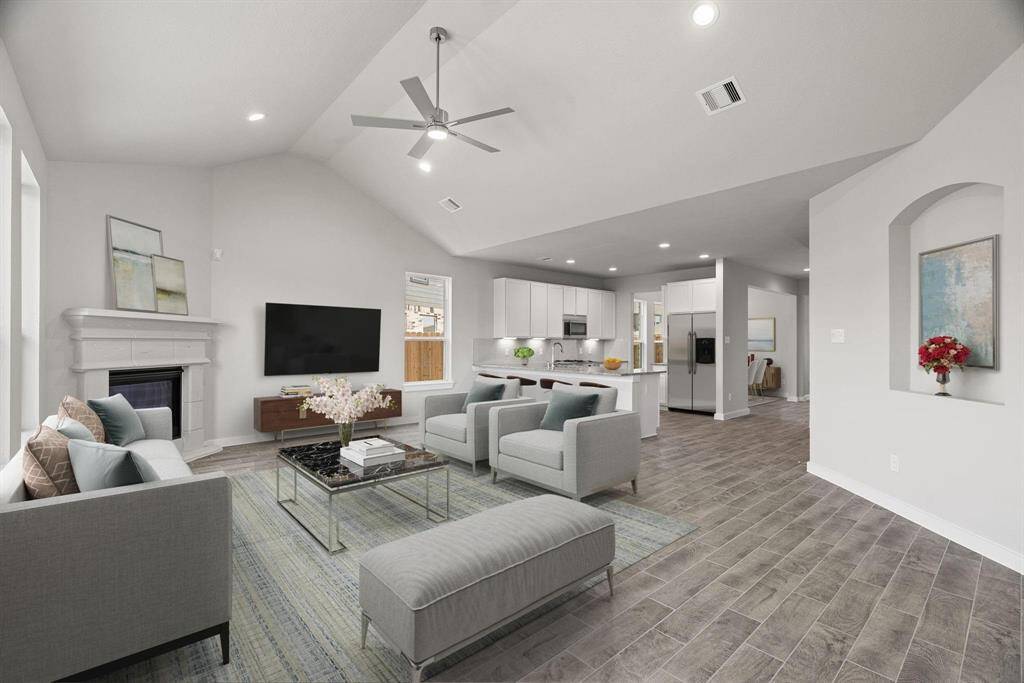 Bring your loved ones and guests together in the inviting family room! Boasting lofty high ceilings, recessed lighting, a stylish ceiling fan, custom paint, stunning flooring, and expansive windows that flood the space with ample natural light all day long. Virtually staged sample photo of completed home with similar floor plan. As-built interior colors and selections may vary.