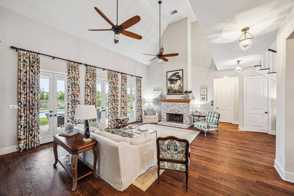 FORMAL LIVING AREA WITH VIEWS TO THE BACK YARD OASIS WITH OPTION TO OPEN THE DOORS AND ALLOW FRESH AIR OR CLOSE THE CURTAINS FOR A PRIVATE AMBIENCE SETTING