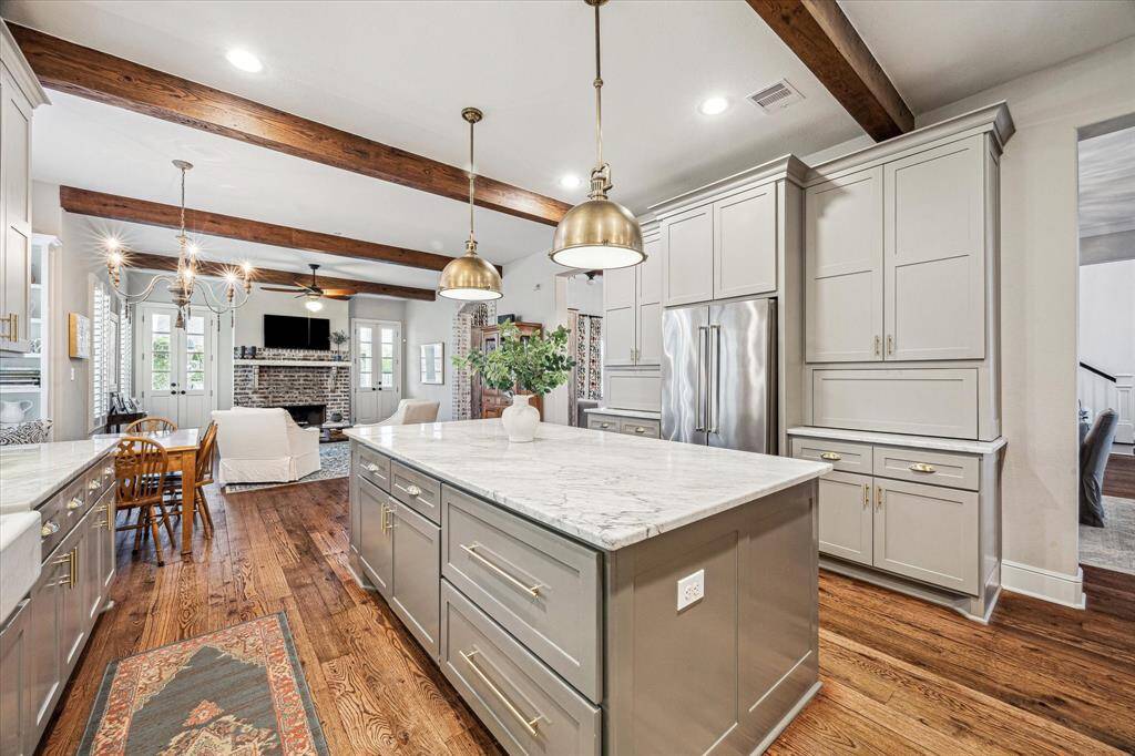 CUSTOM-BUILT CABINETS INCLUDE AMPLE STORAGE AND OFFER 2 “APPLIANCE GARAGE” CABINETS. TO THE RIGHT SITS A LARGE WALK-IN PANTRY W/ SLATE FLOORING, BUILT-IN SHELVES, AUTOMATIC LIGHT SWITCH, AND UNATTACHED MICROWAVE. ACROSS FROM IT SITS THE APPLIANCE PANTRY THAT HOLDS EXTRA PIECES OF LARGE COOKWARE, SERVING AND ENTERTAINING SUPPLIES
