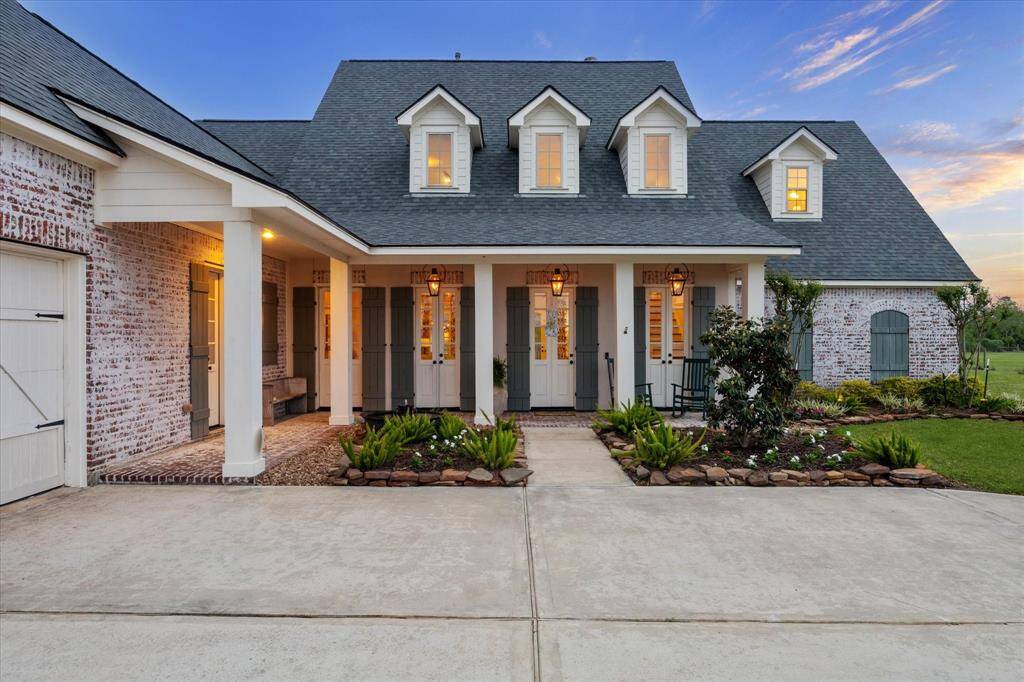 BEVELO GAS LANTERNS LIGHT THE ENTRY WHILE YOU RELAX ON THE COVER PORCH TO THE SERENE SOUNDS OF THE COPPER SUGAR KETTLE WATER FOUNTAIN- THIS CUSTOM PAINTED TREATMENT BRICK HIGH LIGHTS THE FRENCH QUARTER STYLE ELEVATION