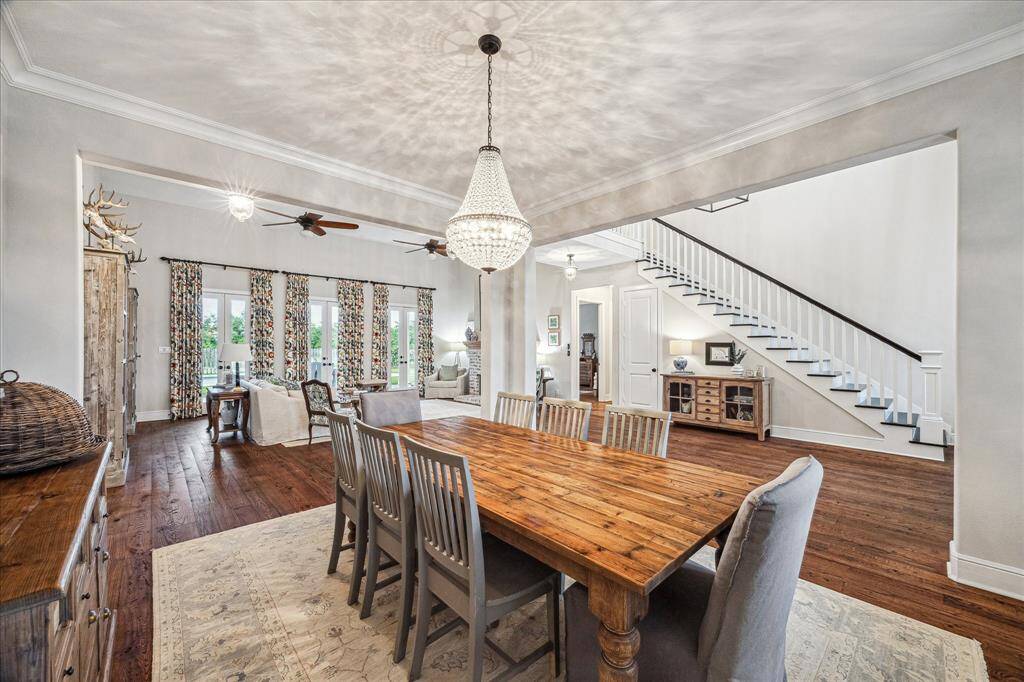 LAVISH FORMAL DINING ROOM IS ADORNED WITH CROWN MOLDING AND A GORGEOUS CUSTOM CHANDELIER