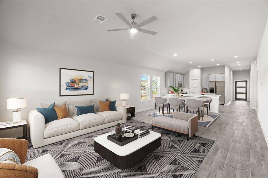 Gather your loved ones and guests in the welcoming living room! Enjoy the spaciousness created by lofty high ceilings, complemented by the glow of recessed lighting and the gentle breeze from a stylish ceiling fan. Admire the custom paint that adds a personalized touch to the room, while the stunning flooring provides both beauty and functionality. Sample photo of completed home with similar floor plan. As-built interior colors and selections may vary.
