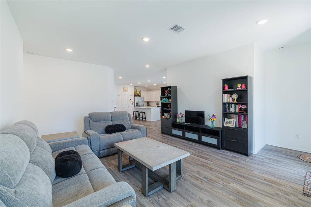 Spacious family room with luxury vinyl flooring is open to the kitchen.