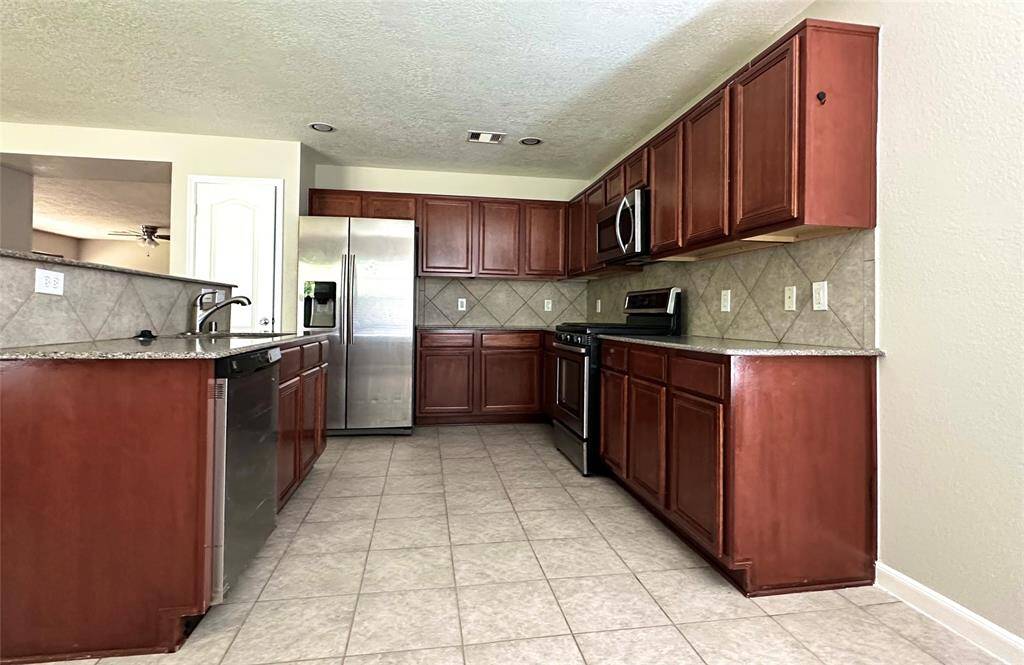 Kitchen with granite counter top and many cabinet spaces