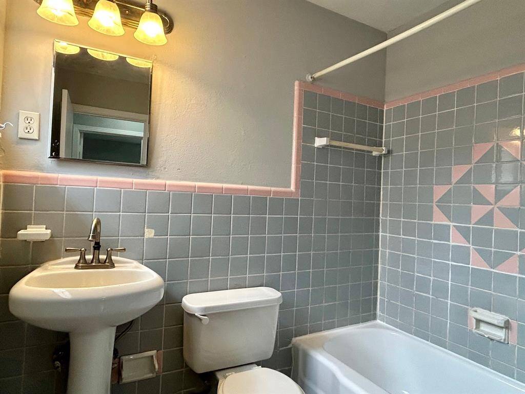 Hallway bathroom with pedestal sink and shower/tub.