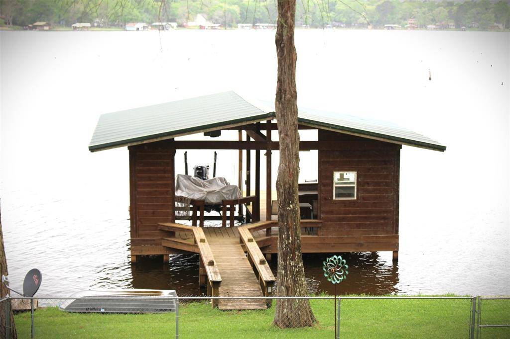 View if boat house from your deck showing fenced back yard with double gates close to the water.