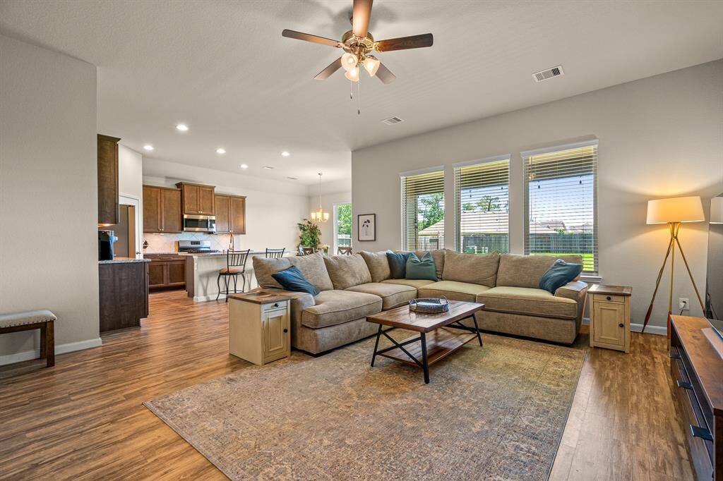Spacious living room with abundant natural light, open floor plan, and seamless flow to the kitchen, perfect for entertaining.