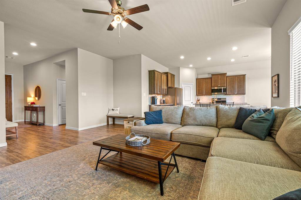 Spacious living room with an inviting open layout and abundant natural light, seamlessly connecting to the kitchen area.
