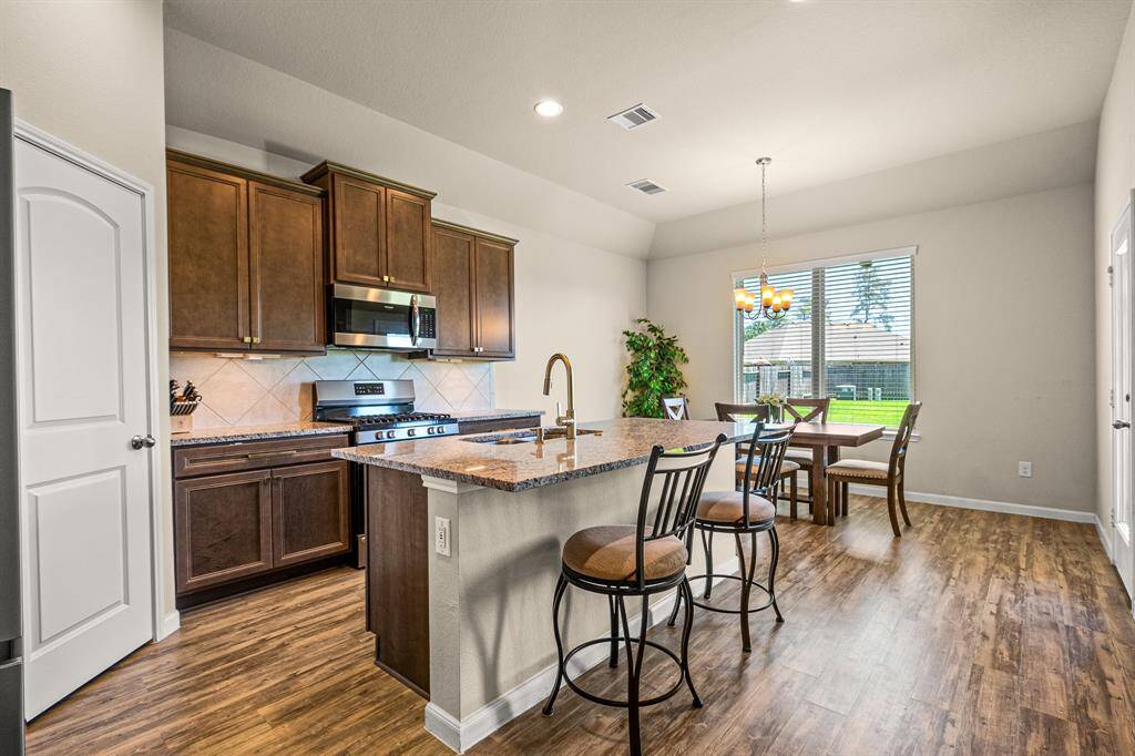 Modern kitchen with elegant cabinetry, granite countertops, and a cozy dining area bathed in natural light.