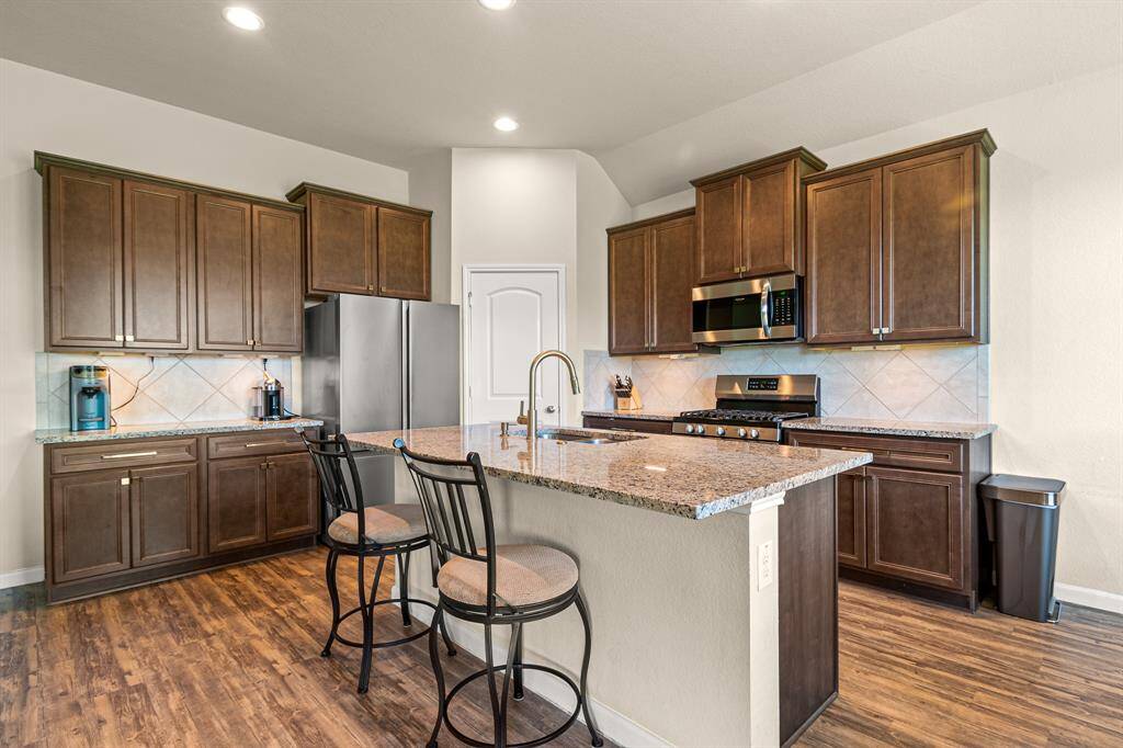 Explore the inviting kitchen, featuring elegant cabinetry, granite countertops, and modern appliances, perfect for any culinary enthusiast.