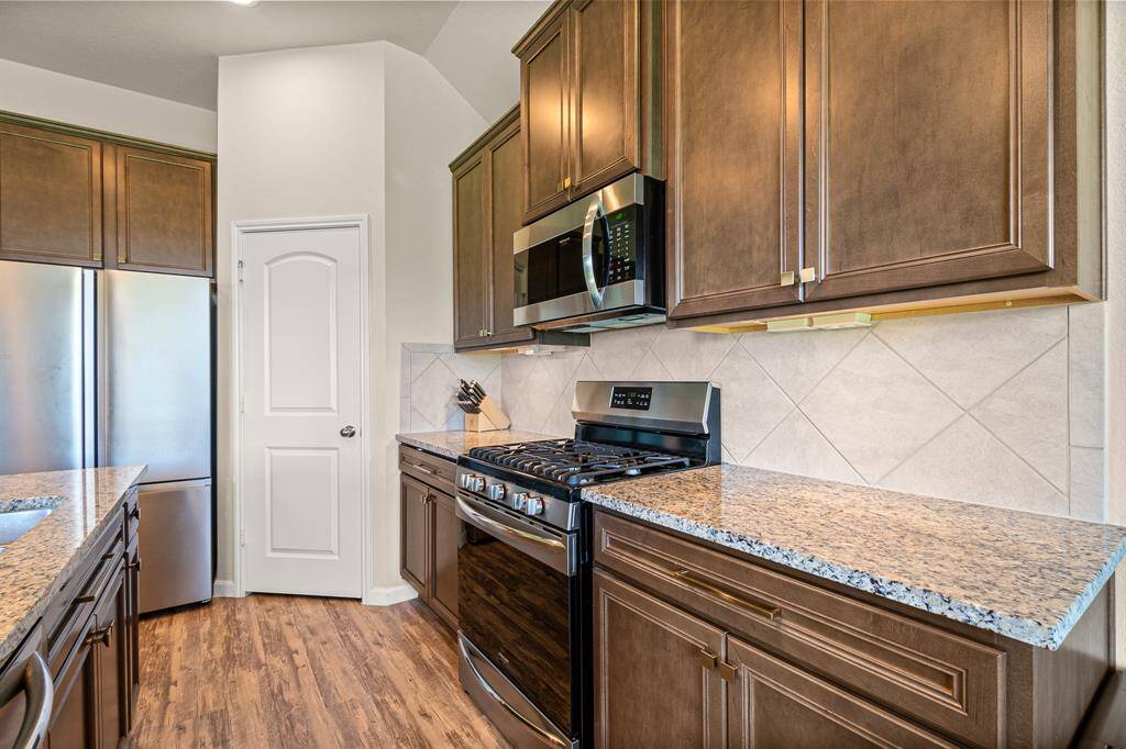 Charming kitchen with sleek appliances, granite countertops, and rich cabinetry.