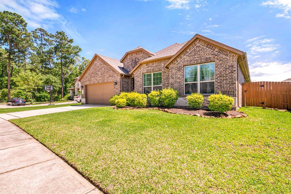Side view showcasing the home's charming brick exterior and lush landscaping.