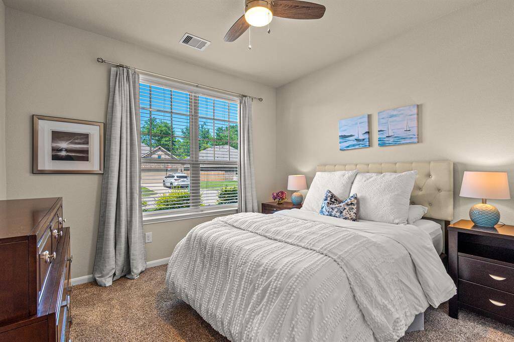 Cozy guest bedroom with abundant natural light.
