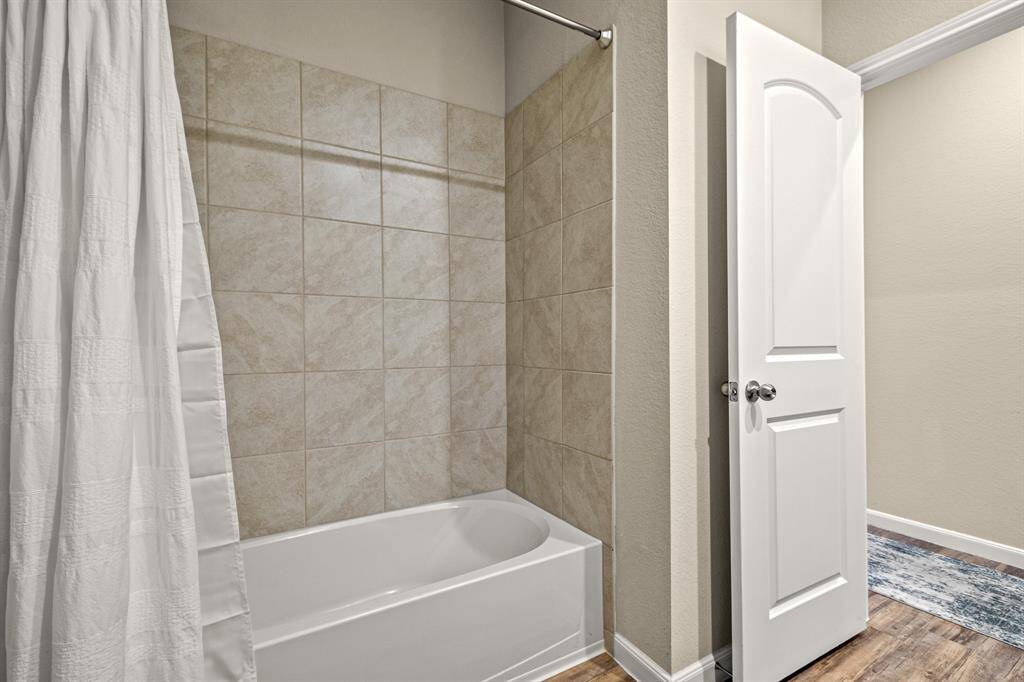 Charming secondary bathroom featuring a sleek tiled shower.