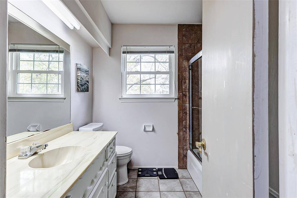 Guests will appreciate this full bathroom, featuring a large vanity, ample lighting, and a tub/shower combination, providing both comfort and convenience.