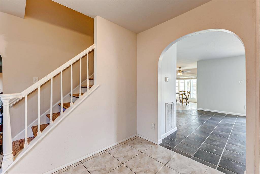 Welcome inside! As you enter, you are greeted by a tiled foyer with arched openings leading to the formal living room (on the right), the formal dining room (on the left), and the main living area straight ahead.
