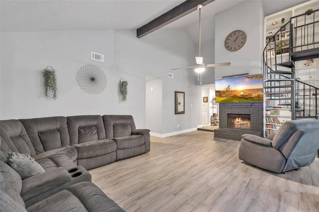 Beautiful family room with winding staircase going up to the loft, with a gorgeous bookshelf behind!!