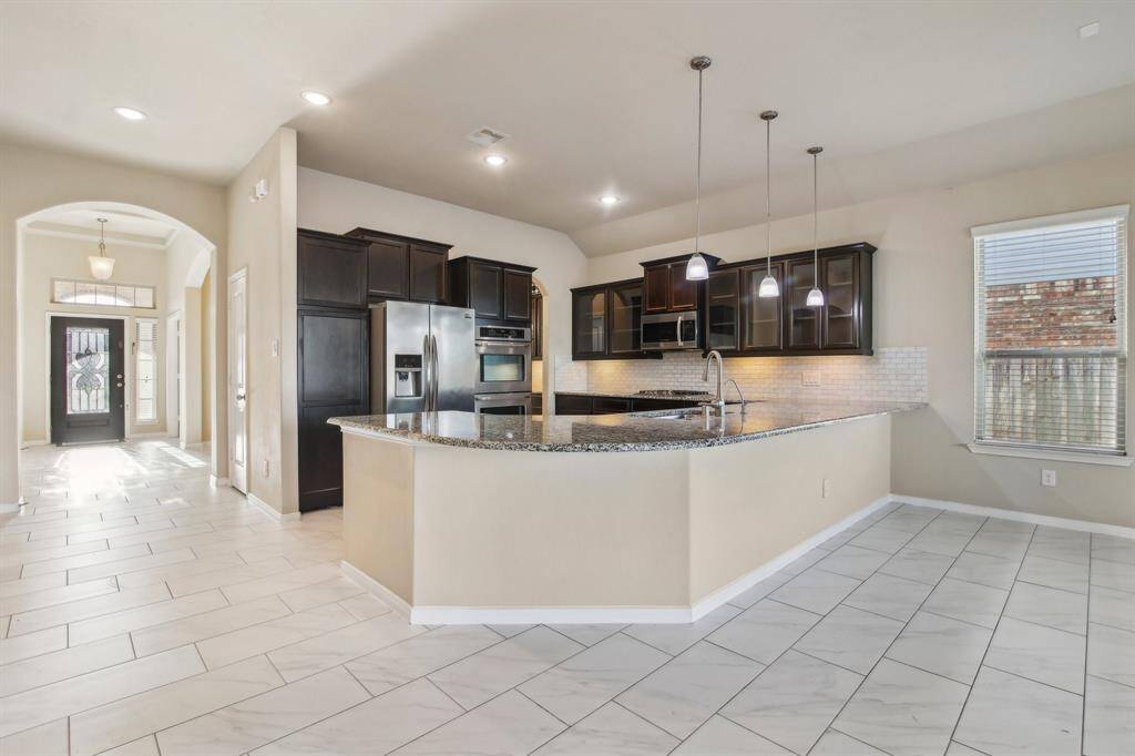 Gourmet kitchen with a built-in double oven and granite countertops.