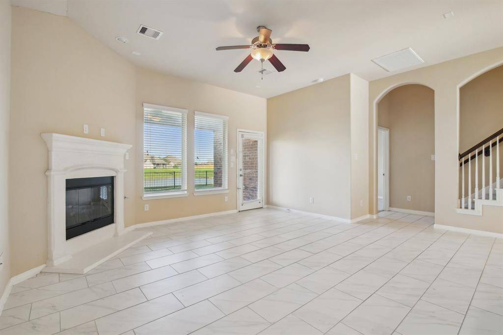 Spacious living room featuring a gaslog fireplace with an amazing view of the lake.