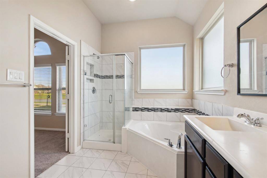 Primary bathroom with double sinks and a separate shower and tub.