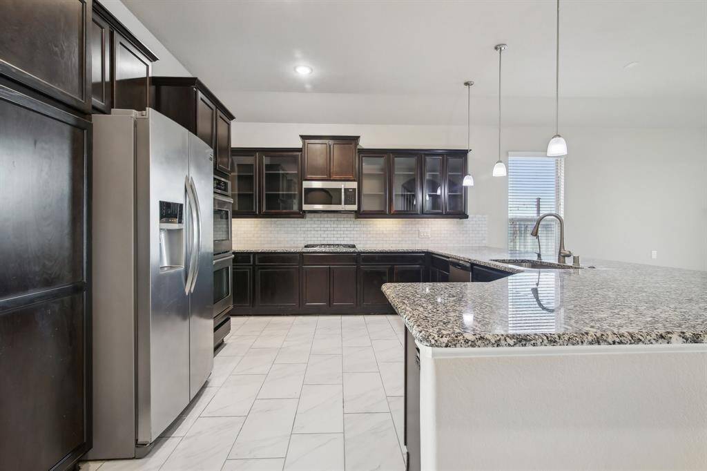 Gourmet kitchen with a built-in double oven and granite countertops.