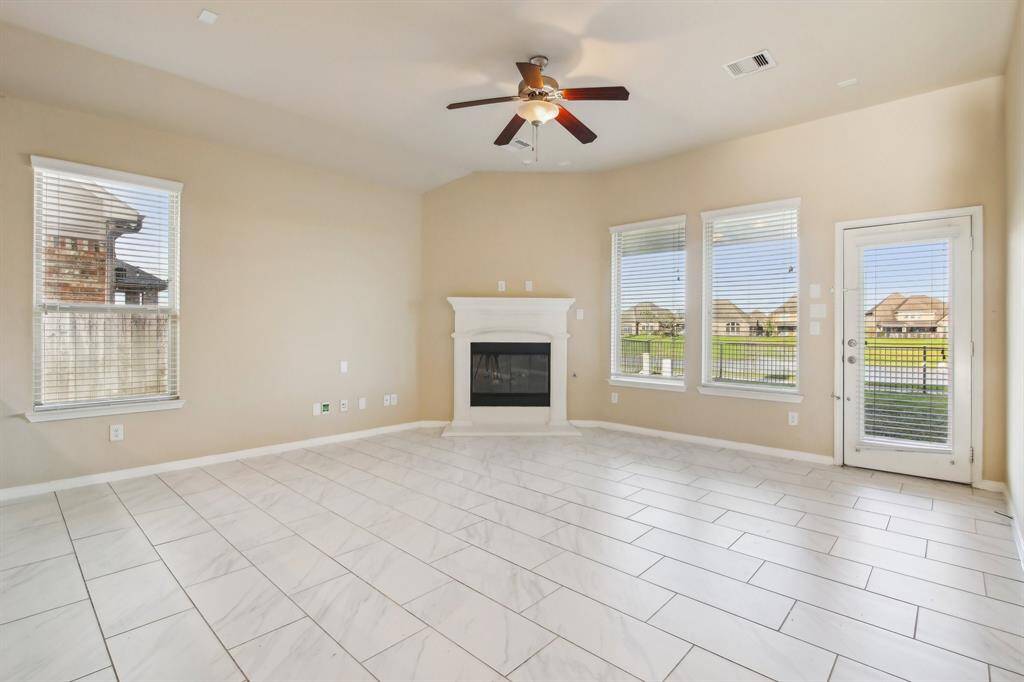 Spacious living room featuring a gaslog fireplace with an amazing view of the lake.