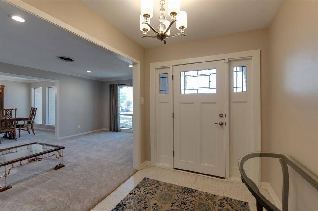 Inviting entry. Home has original Terrazzo floors and glass paneled front door that lets in the natural light. Formal living room to the left.
