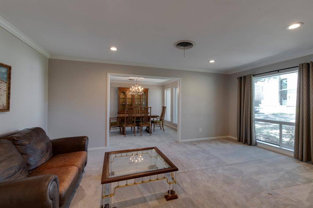 Large formal living room can be used as a option for a large dining room. Large windows and recessed lighting and carpet in the space.