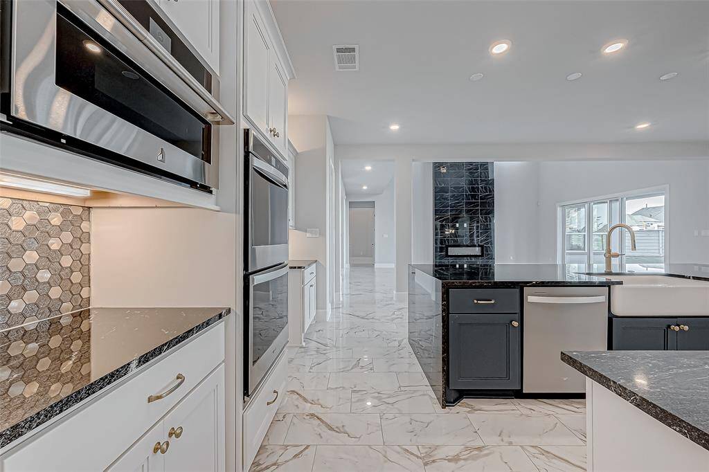 The dazzling hexagon mosaic tile backsplash and under-cabinet lighting add a touch of glamor.