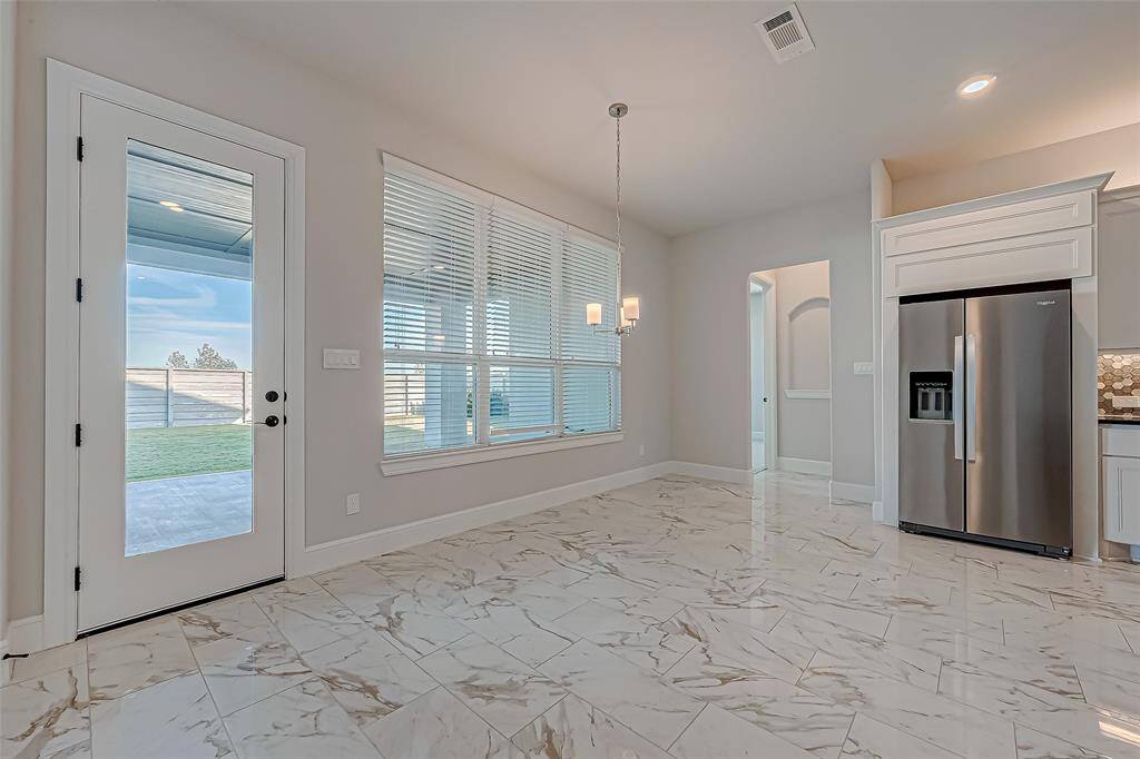 The adjacent breakfast area, with a large window, offers a sunny spot to start your day.