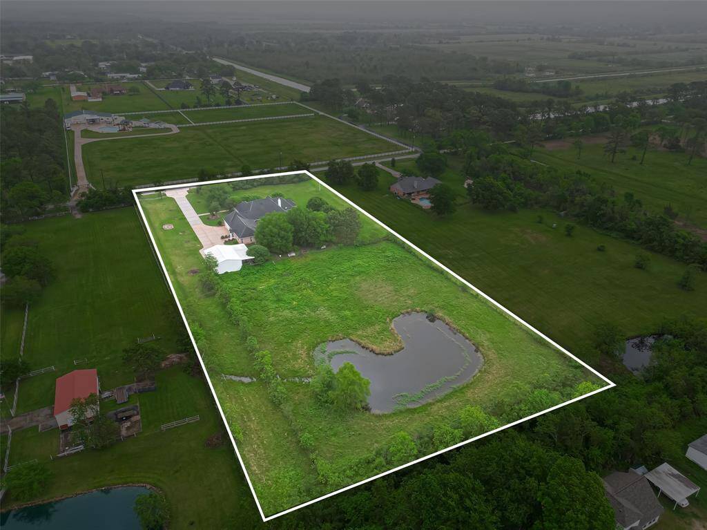 aerial view of property shows large pond