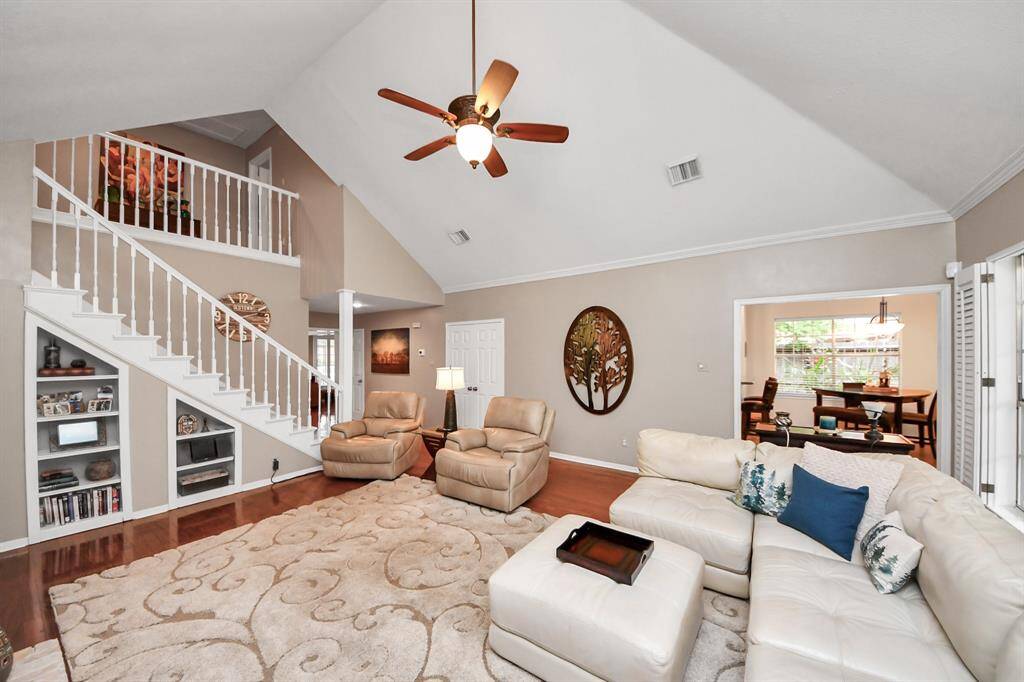 The striking staircase adds architectural interest to the room, which is spacious enough to accommodate large furniture pieces and host a grand gathering.