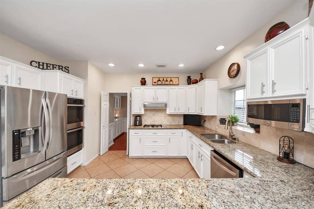 The expansive kitchen offers a dream layout for any chef, featuring abundant cabinetry and plenty of counter space for effortless meal preparation.