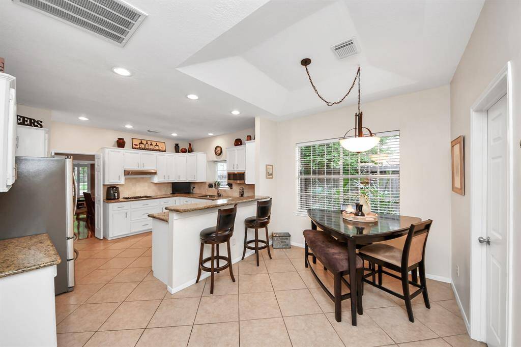 A convenient breakfast bar invites conversation while cooking, perfect for snacking or enjoying quick meals on the go, while the nearby breakfast area offers ample space for a large table, ideal for more casual mealtimes.