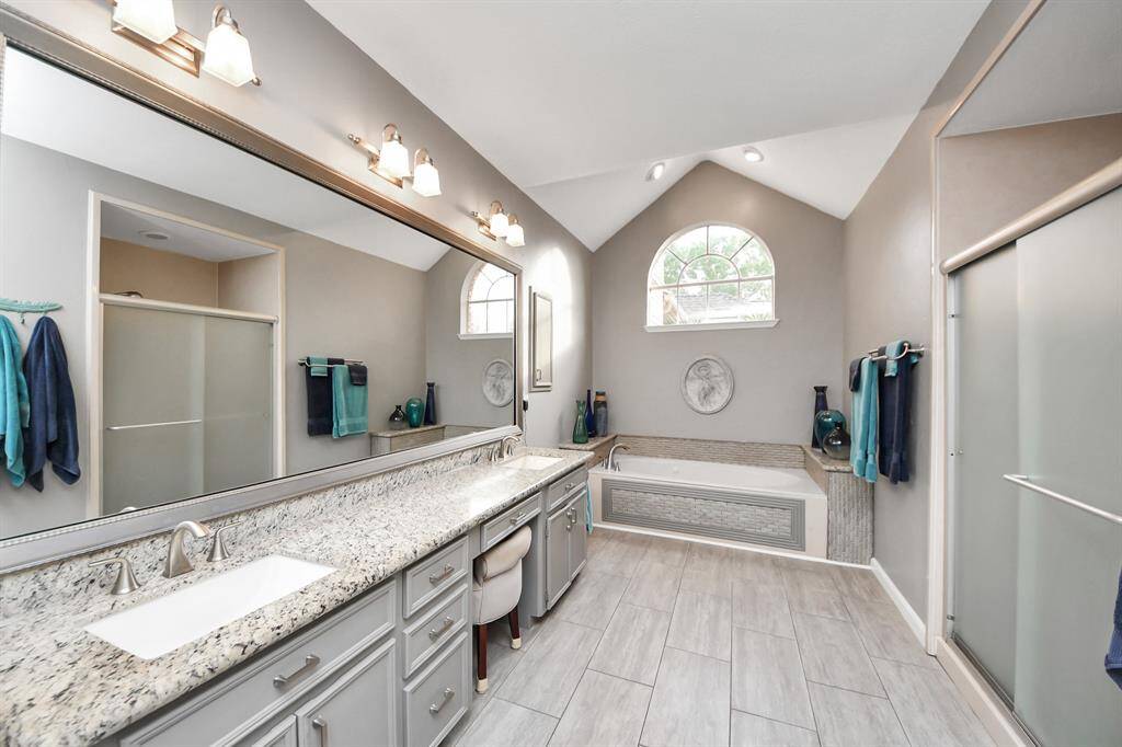 Spa-like in every sense, this bathroom is designed for you to unwind and enjoy the end of the day in ultimate relaxation.  A large, streaming-ready shower on the right adds to the experience.