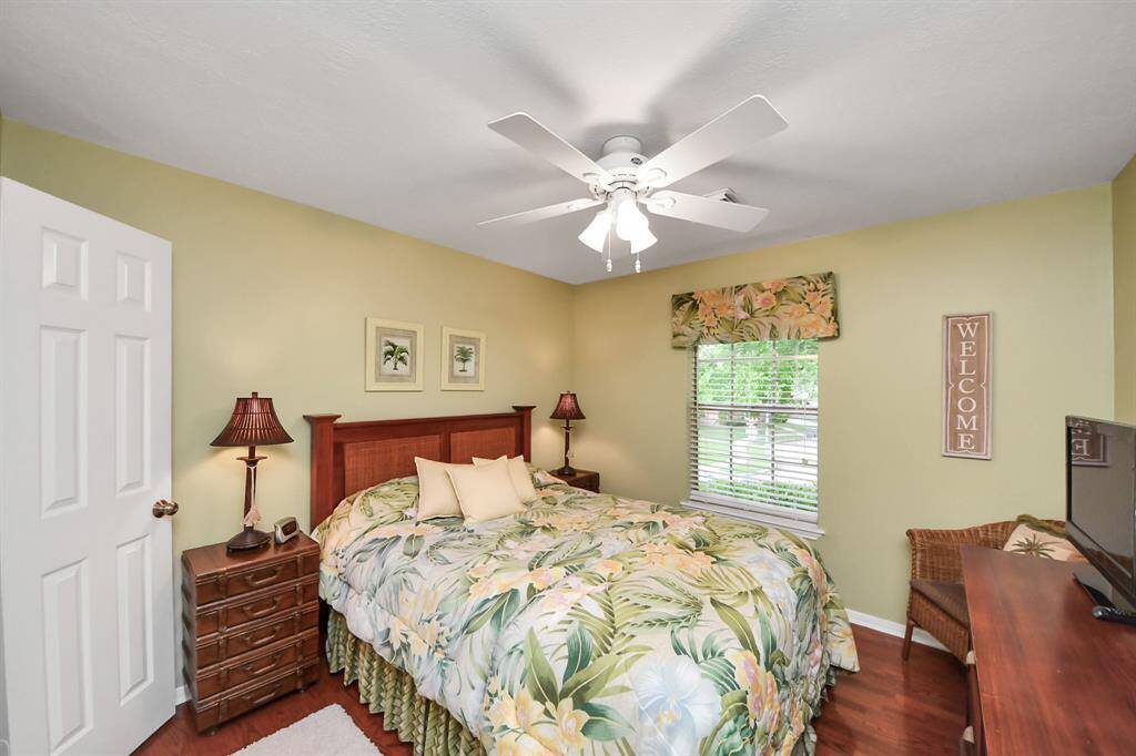 One of three spacious bedrooms upstairs, each featuring beautiful wood flooring and offering plenty of room for personalization.