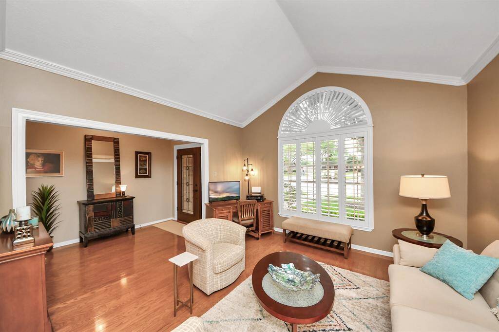 A formal living room welcomes you upon entry, featuring stunning window shutters that add both charm and sophistication.