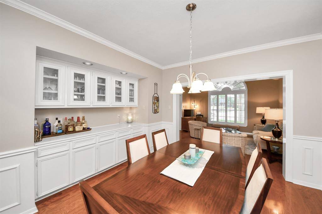 Custom built-ins with an elongated countertop and glass-front cabinets add both elegance and function—perfect for serving food and cocktails.