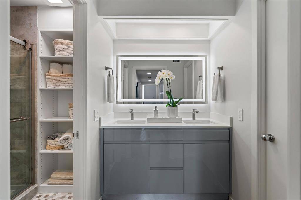 Double sink vanity, custom lacquered cabinetry, Quartz counter tops and LED lit mirror.