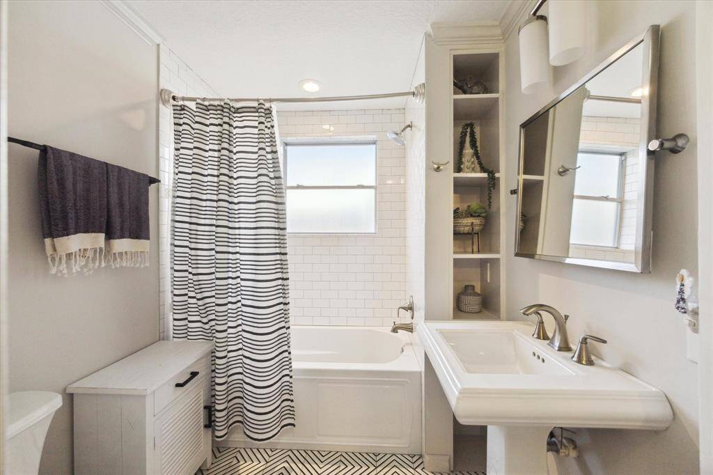 The second bathroom features a modern ceramic floor tile, classic subway tile and a mirror from Restoration Hardware.