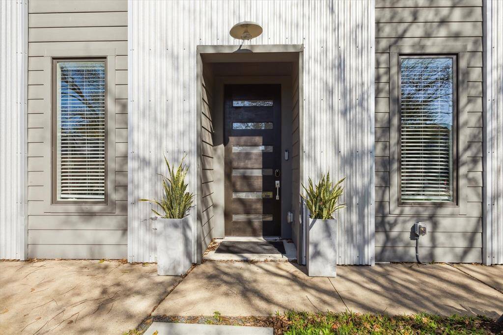 Striking entry with a modern wood and glass door.